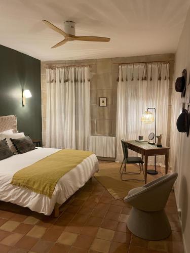 une chambre avec un lit et un bureau avec une chaise dans l'établissement Le MasChica Arles Centre, à Arles
