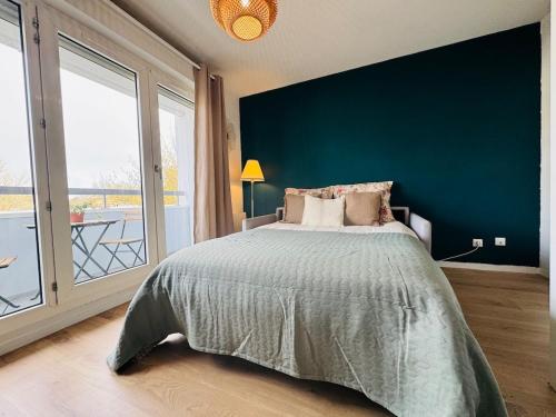 a bedroom with a large bed with a blue wall at Le Bocal - Private Parking - Wi-Fi in Gradignan