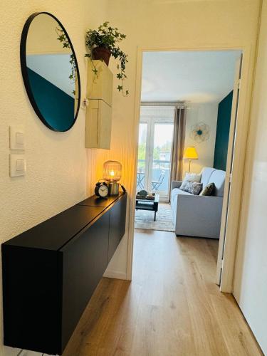 a living room with a black dresser and a mirror at Le Bocal - Private Parking - Wi-Fi in Gradignan