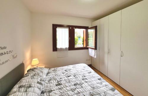 a bedroom with a bed and a window at Garden Thermae in Nago-Torbole