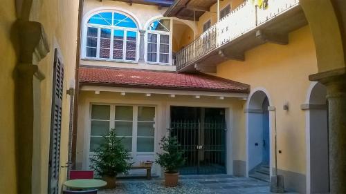 a building with a balcony and two potted plants at Le Corti in Cannobio
