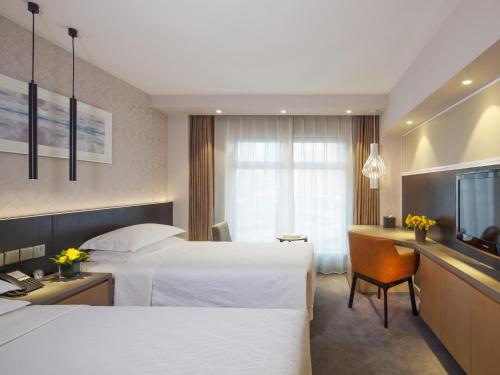 a hotel room with two beds and a television at Beijing Landmark Towers in Beijing