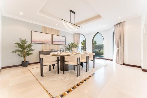 a dining room with a table and chairs at Beachfront 6BR and Assistant's Room Villa with Private Pool, Palm Villa, Palm Jumeirah by Deluxe Holiday Homes in Dubai
