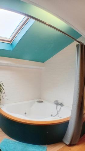 Cette chambre dispose d'une baignoire et d'une lucarne. dans l'établissement Appartement privé avec terrasse en centre ville, à Montpellier