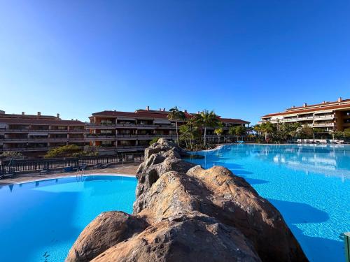 een groot zwembad met blauw water voor de gebouwen bij Tropicalidays Jardines del Teide in Puerto de la Cruz