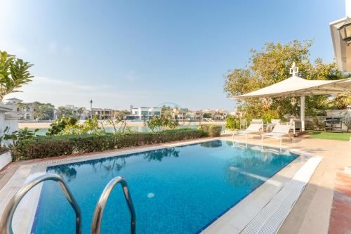 an image of a swimming pool in a house at Beachfront 6BR and Assistant's Room Villa with Private Pool, Palm Villa, Palm Jumeirah by Deluxe Holiday Homes in Dubai