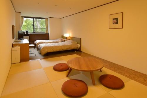 a living room with a bed and a table and a table at Hotel Kanronomori in Niseko