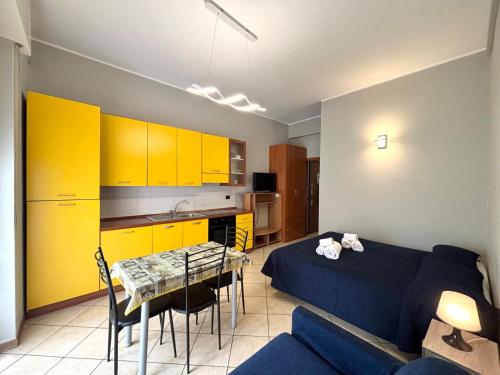 a living room with a bed and a table and yellow cabinets at Residence Oasi Di Monza in Monza