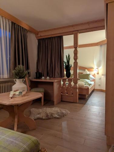 a room with a bedroom with a bed and a table at Wald Villa Schönau in Schönau an der Brend