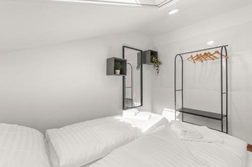a white bedroom with two beds and a mirror at Rustic Vineyard House in Modra