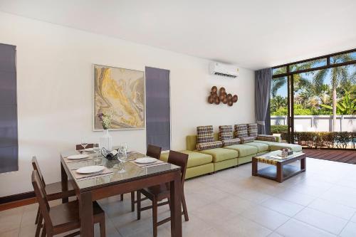a living room with a table and a yellow couch at 3BR Pool Access Villa Argent 9, near Nai Yang and Nai Thon Beaches in Thalang