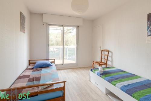 une chambre avec deux lits et une fenêtre dans l'établissement Limousin - proche mer - parking, à La Baule