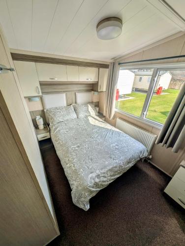 a bed in the middle of a small room at Golden Palm Getaway's PG143 in Skegness