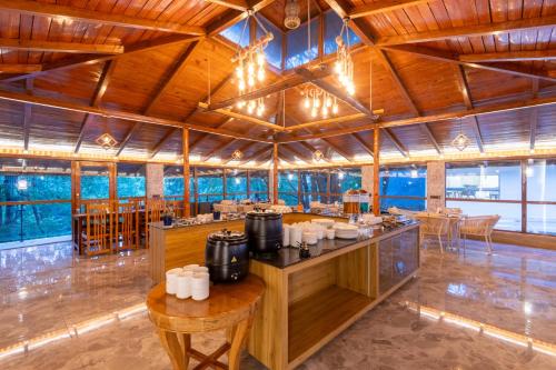 a restaurant with wooden ceilings and tables and chairs at DLS Hotels Emerald in Nainital