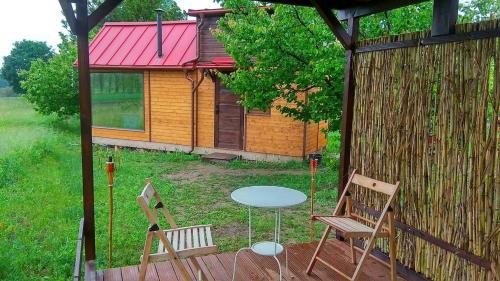 two chairs and a table in front of a cabin at An original Tiny House WiFi, AC, Bikes, HO compatible in Pátka