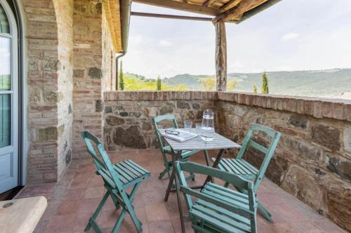 a patio with a table and chairs on a stone wall at Wp Relais Villa Vignalunga in Bagno Vignoni