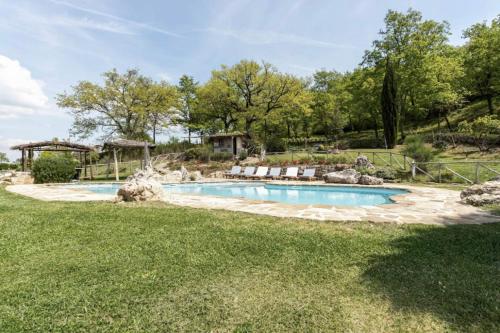 a swimming pool in a yard with a patio at Wp Relais Villa Vignalunga in Bagno Vignoni