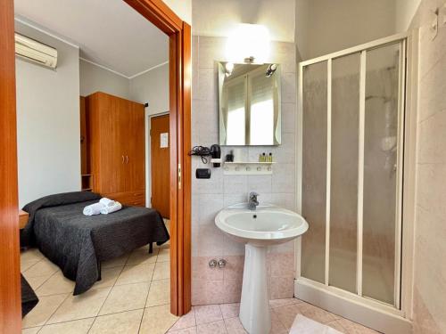 a bathroom with a sink and a shower and a bed at Residence Oasi Di Monza in Monza