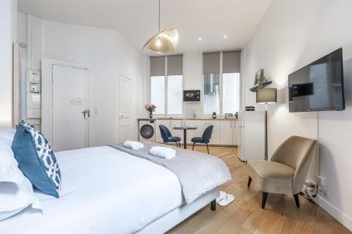 une chambre blanche avec un lit et une cuisine dans l'établissement Champs Elysées - Amazing Apartment - Studio, à Paris