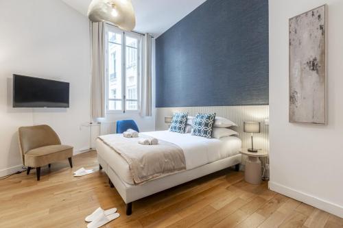 une chambre avec un grand lit et une chaise dans l'établissement Champs Elysées - Amazing Apartment - Studio, à Paris