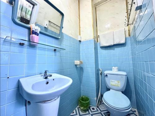 a blue tiled bathroom with a toilet and a sink at My Hao Hotel Ho Chi Minh City in Ho Chi Minh City