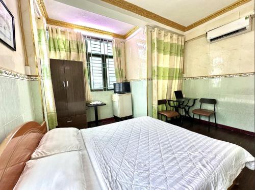 a bedroom with a bed and a table and chairs at My Hao Hotel Ho Chi Minh City in Ho Chi Minh City