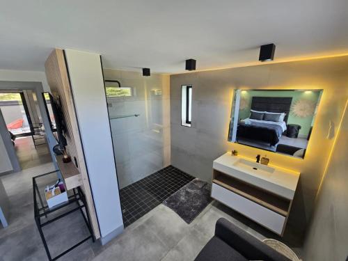 Un baño con lavabo, espejo y cama. en The Block, en Wilderness