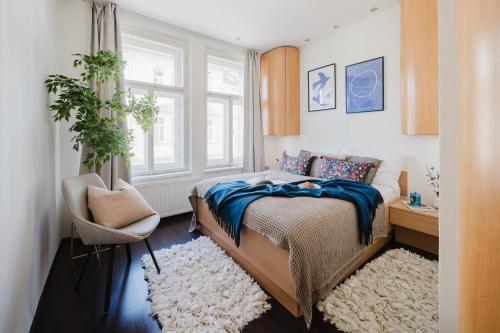 um quarto com uma cama, uma cadeira e uma janela em Prague Days - Stylish Apartment - Netflix - Hip District em Praga