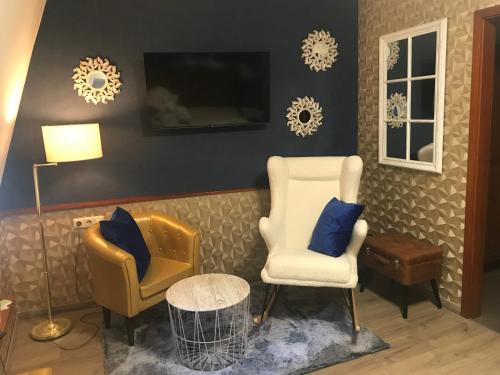 a living room with two chairs and a tv at Hotel & Restaurant Sonnenhöfle in Sommerhausen