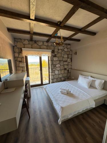 a bedroom with a large bed and a window at Bademli Han Otel in Ulucak