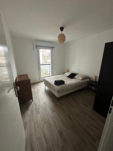 une chambre blanche avec un lit et une fenêtre dans l'établissement Appartement T2 aux portes de Paris - Parking privatif, à Villejuif