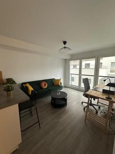 un salon avec un canapé vert et une table dans l'établissement Appartement T2 aux portes de Paris - Parking privatif, à Villejuif