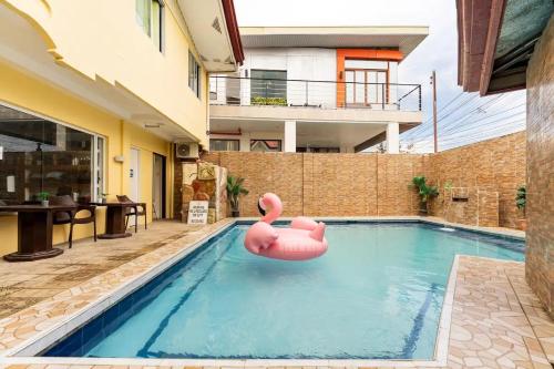 a pool with a pink inflatable flamingo in the water at Laciaville Resort and Hotel Inc in Lapu Lapu City