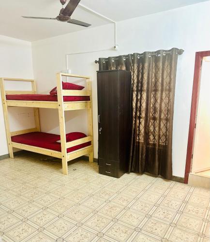 a room with two bunk beds and a curtain at Alora Homes Ladies Pg in Bengaluru