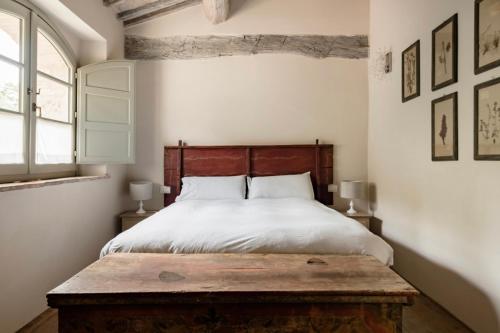 a bedroom with a bed and a wooden table at Wp Relais Villa Vignalunga in Bagno Vignoni