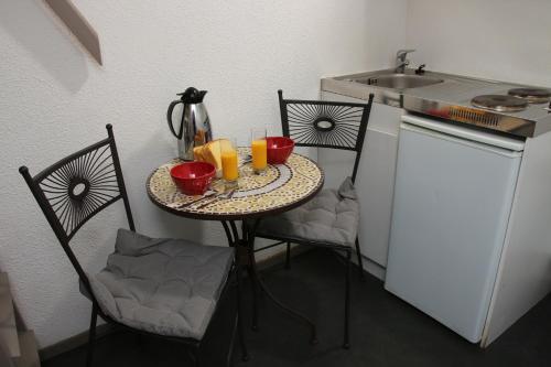 - une petite cuisine avec une table, 2 chaises et un évier dans l'établissement Motel du Val André, à Pléneuf-Val-André