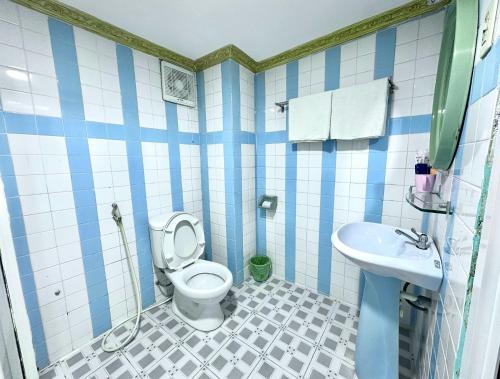 a blue and white bathroom with a toilet and sink at My Hao Hotel Ho Chi Minh City in Ho Chi Minh City