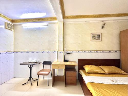 a bedroom with a bed and a table and a chair at My Hao Hotel Ho Chi Minh City in Ho Chi Minh City
