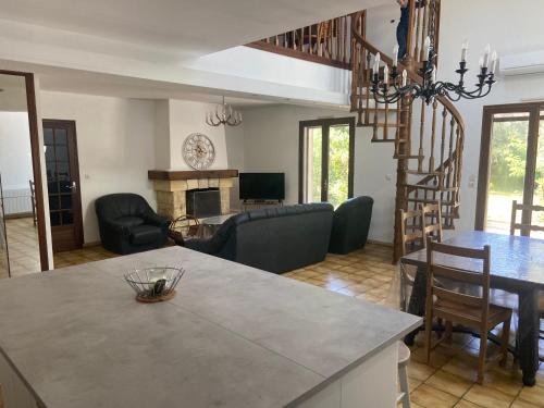 Il comprend une cuisine et un salon avec un escalier en colimaçon. dans l'établissement Maison au calme à proximité du lac, à Maubuisson