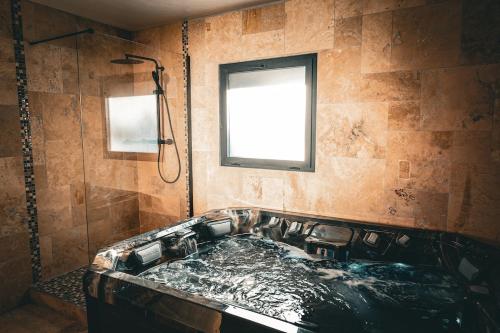une baignoire dans une salle de bain avec une fenêtre dans l'établissement A slice of heaven in Savigny, à Savigny