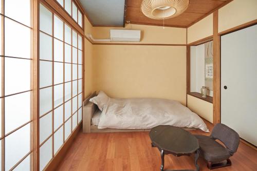 a small bedroom with a bed and a table at 美術の宿 箱根もみじの森 in Hakone