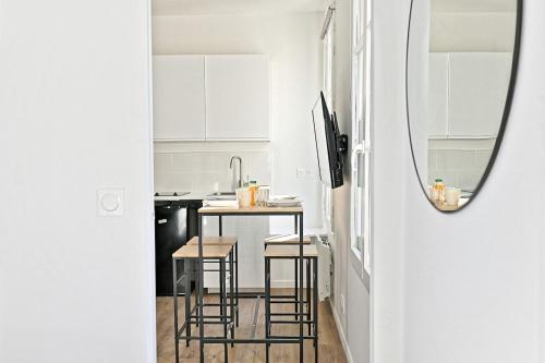 - une petite cuisine avec une table et des tabourets dans l'établissement Convenient apartment near Gare de Lyon, à Paris