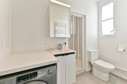 une salle de bain avec machine à laver et toilettes dans l'établissement Convenient apartment near Gare de Lyon, à Paris