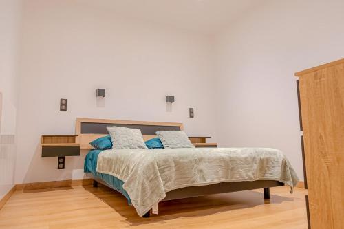 une chambre avec un lit avec des oreillers bleus dans l'établissement A slice of heaven in Savigny, à Savigny