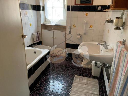 a bathroom with two toilets and a sink and a tub at La Casa dei Nonni in Bracciano