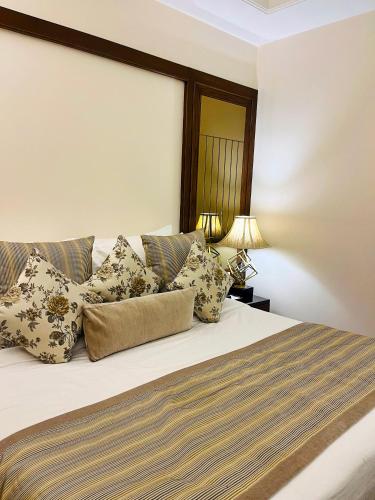 a bedroom with a bed with pillows on it at Hotel Home In By Amrik Sukhdev in Sonīpat