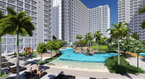 マニラにあるUnistay SHORE Residence w Balcony Amazing Manila Bay view near MOAのヤシの木と建物が並ぶリゾート内のスイミングプール
