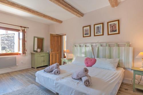 une chambre avec un lit avec deux animaux en peluche dessus dans l'établissement Le Cœur de Garrigues - Piscine Privée, à Garrigues-et-Sainte-Eulalie