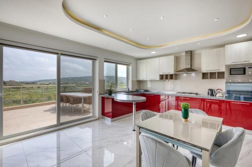a kitchen with red cabinets and a table with chairs at The Marylou penthouse in Mġarr