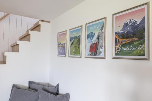 a group of pictures on a wall above a couch at LEVA Stay Luzern-Interlaken I Nature I Familie in Sarnen